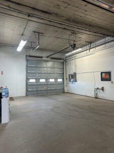 Interior of a car garage, featuring a garage door.
