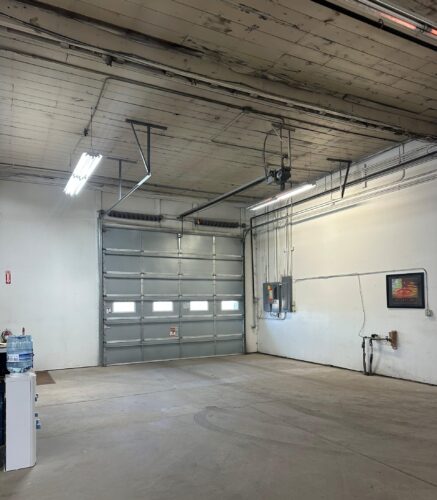 Interior of a car garage, featuring a garage door.