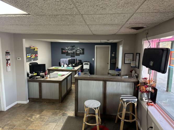 Interior of a car garage with tables and stools.
